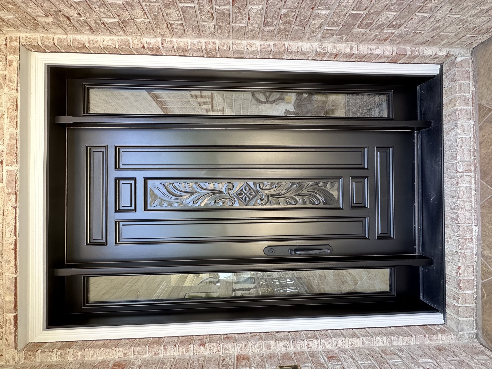 The same carved front entry door after refinishing in satin black.