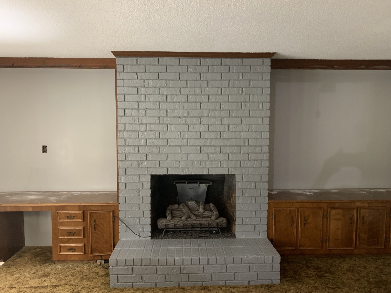 The same brick fireplace after being painted a soft gray.