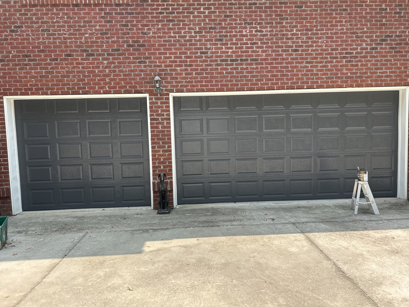 The same two garage doors after repainting in a dark charcoal color.