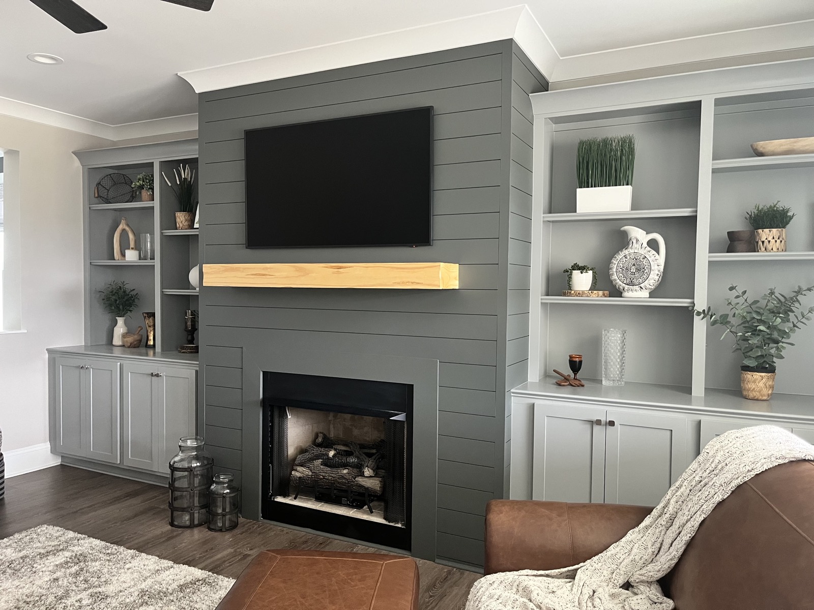 Living room with painted built-ins and a dark shiplap fireplace surround.